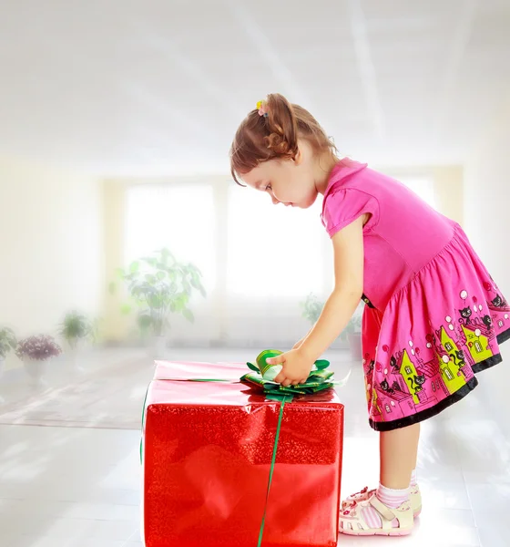 Little girl looking at a gift — Stock Photo, Image