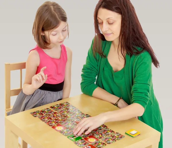 The teacher and the girl at the table studying the cards — Stock Photo, Image