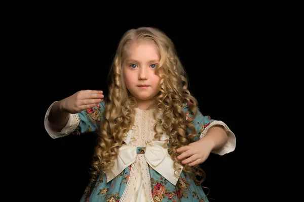 Uma menina em um traje de boneca repete seus movimentos. — Fotografia de Stock