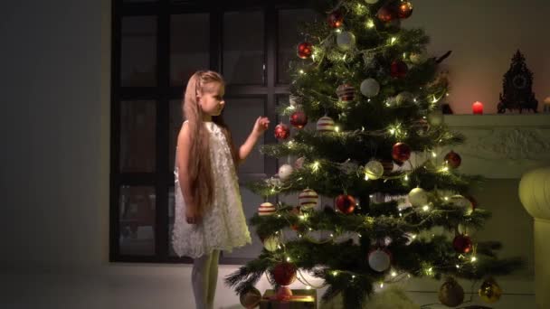 สาวน้อยตกแต่งต้นคริสต์มาส แนวคิดปีใหม่ วันหยุดครอบครัว . — วีดีโอสต็อก