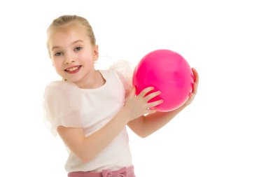 Küçük kız spor olsun diye büyük bir topla oynuyor.