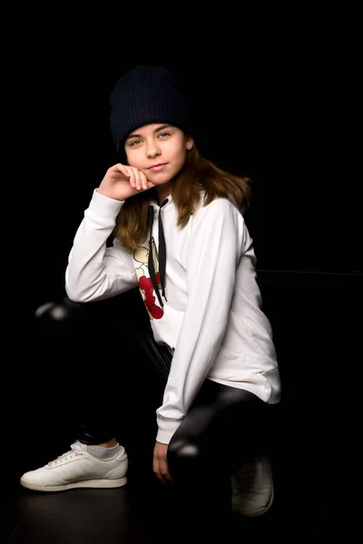 Menina adolescente em um terno de esportes da juventude. Em um fundo preto. — Fotografia de Stock