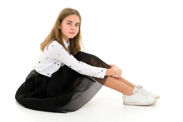 Uma menina a abraçar os joelhos. sentado no chão. — Fotografia de Stock