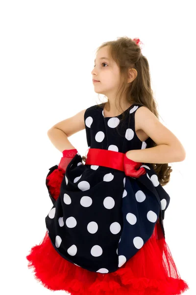 Charmant meisje in een blauwe polka dot jurk met handen op de taille. — Stockfoto