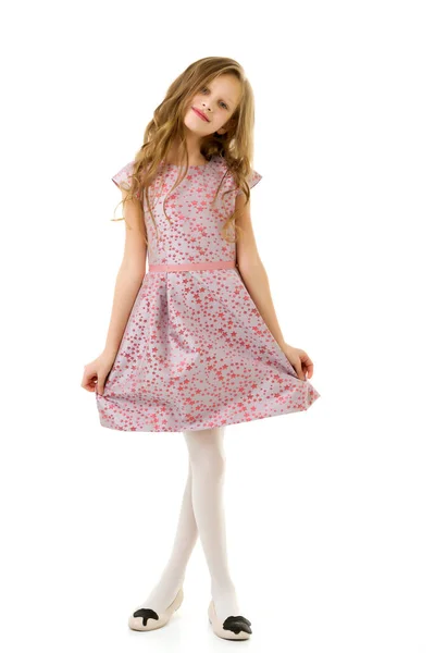 Sorrindo menina loira com cabelos longos de pé segurando Hem de seu vestido. — Fotografia de Stock