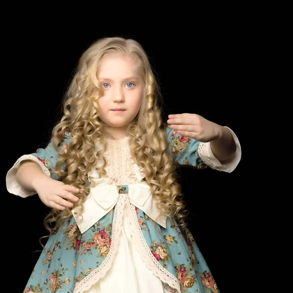 Een klein meisje in een pop kostuum herhaalt haar bewegingen. — Stockfoto