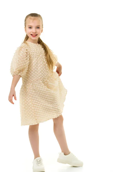 Malá holka se drží za ruce na okrajích sukně. — Stock fotografie