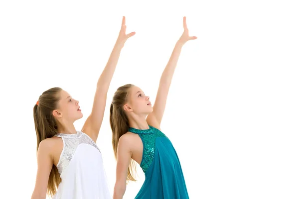 Дві сестри в спортивних сукнях танцюють в студії на білому тлі . — стокове фото