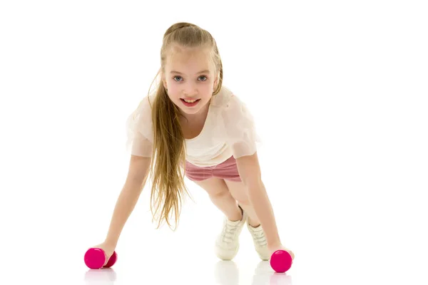 Little girl doing exercises with dumbbells. — Stock Photo, Image