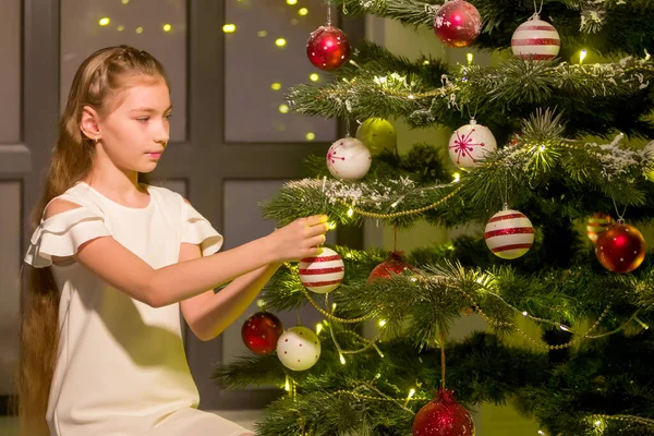 Little girl decorates a Christmas tree. New Year concept, family holidays. — Stock Photo, Image