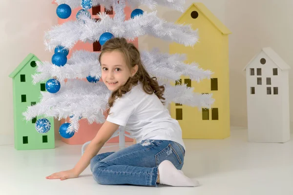 Preteen fille posant devant l'arbre de Noël blanc avec des billes bleues. — Photo