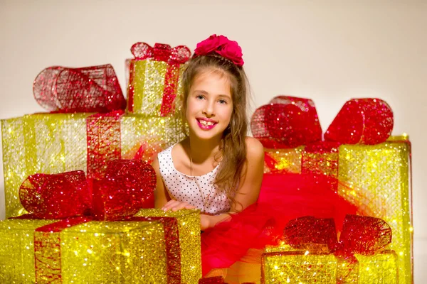 Klein schattig meisje op zoek naar binnen van gloeiende kerstcadeau doos — Stockfoto