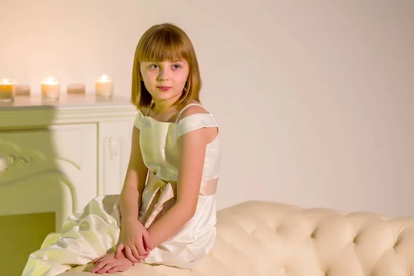 Uma menina em um quarto escuro à luz das velas. — Fotografia de Stock