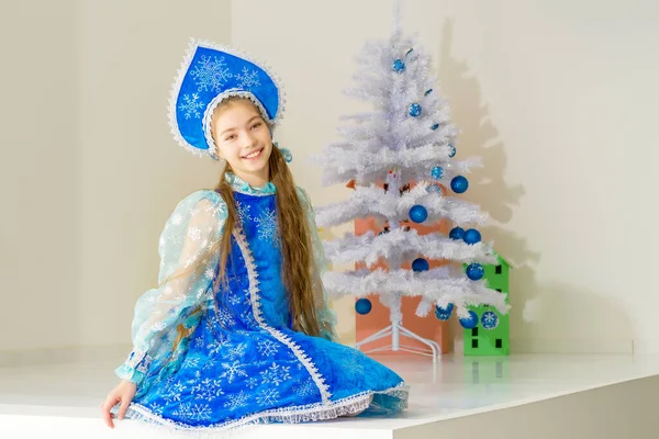 Niña Nieve doncella cerca del árbol de Año Nuevo. —  Fotos de Stock