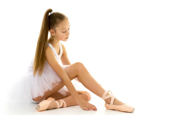 Girl ballerina puts on pointe shoes. The concept of dancing. Stock Photo