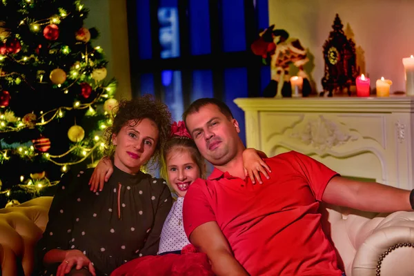 Genç bir aile Noel 'i evde kutluyor. Mutlu, genç bir aile tatillerinin tadını çıkarıyor.. — Stok fotoğraf