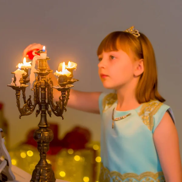 Маленькая девочка зажигает свечи в Рождественскую ночь. — стоковое фото