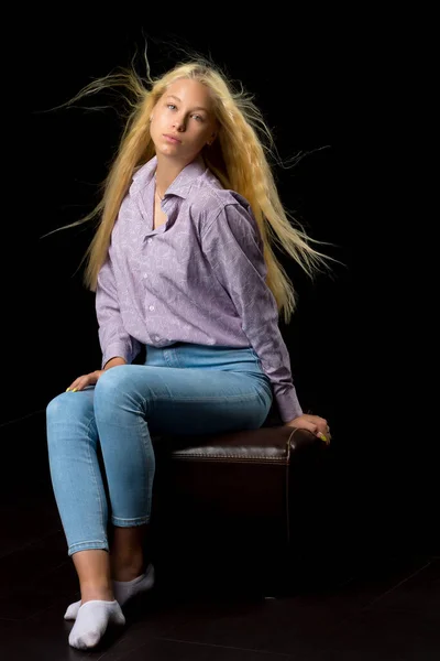Cute uśmiechnięta blondynka dziewczyna siedzi na wysokim krześle w studio — Zdjęcie stockowe