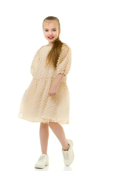Malá holka se drží za ruce na okrajích sukně. — Stock fotografie