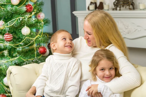 Szczęśliwa rodzina siedzi na kanapie we wnętrzu świąt Bożego Narodzenia. — Zdjęcie stockowe