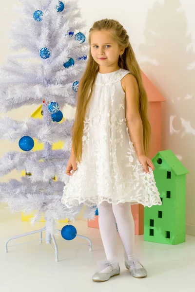 Chica en vestido elegante sentada en el suelo delante del árbol de Navidad. —  Fotos de Stock