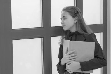 Pencerenin kenarında kitap okuyan sevimli küçük bir kız..