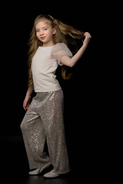 Una hermosa niña endereza su cabello en su cabeza. — Foto de Stock