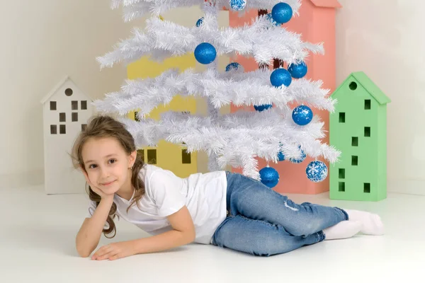 Ragazza in posa davanti all'albero di Natale bianco con Blue Baubles. — Foto Stock