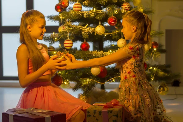 Kızlar Noel 'in önünde oturmuş birbirlerine bakıyorlar. — Stok fotoğraf