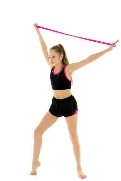 Ένα κορίτσι γυμνάστρια εκτελεί ασκήσεις με ένα σχοινί παρακάμπτοντας. — Φωτογραφία Αρχείου