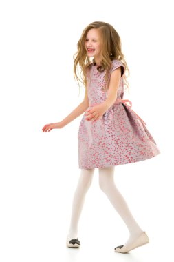 Pembe elbiseli, uzun saçlı mutlu kız eğleniyor.