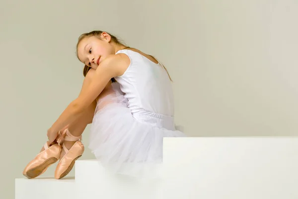 Girl ballerina puts on pointe shoes. The concept of dancing. — Stock Photo, Image