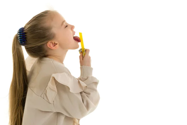Roztomilá holčička olizuje bonbón. — Stock fotografie
