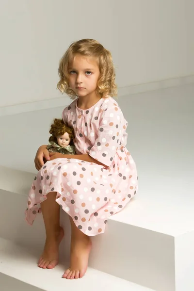 Linda niña jugando con una muñeca. — Foto de Stock