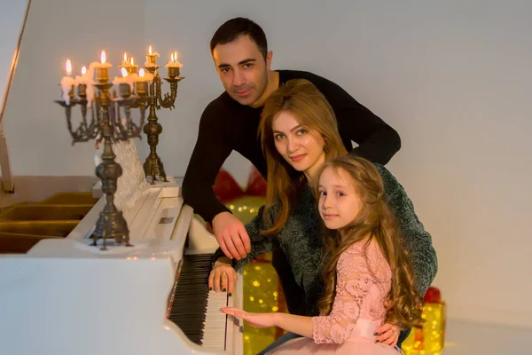 Happy Family Posing κοντά Πιάνο Διακοσμημένο με Καμένα Κεριά — Φωτογραφία Αρχείου