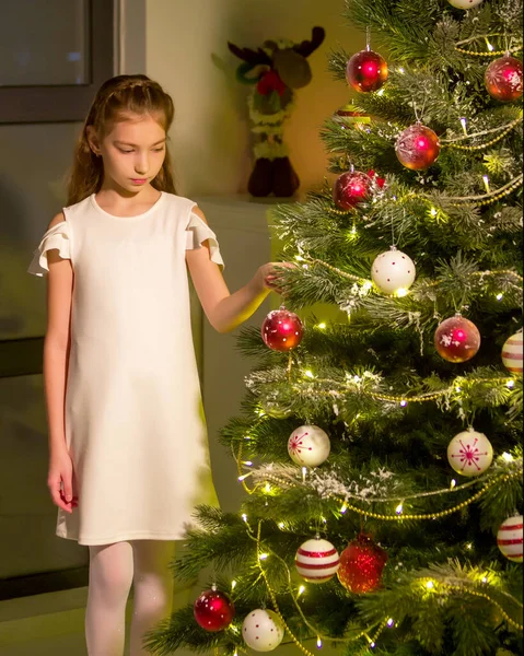 Little girl decorates a Christmas tree. New Year concept, family holidays. — Stock Photo, Image