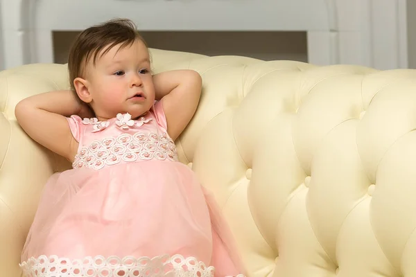Jolie jolie tout-petit fille relaxant au canapé confortable en cuir — Photo
