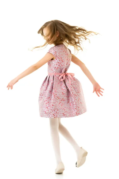 Chica feliz con el pelo largo que usa vestido rosa que se divierte —  Fotos de Stock