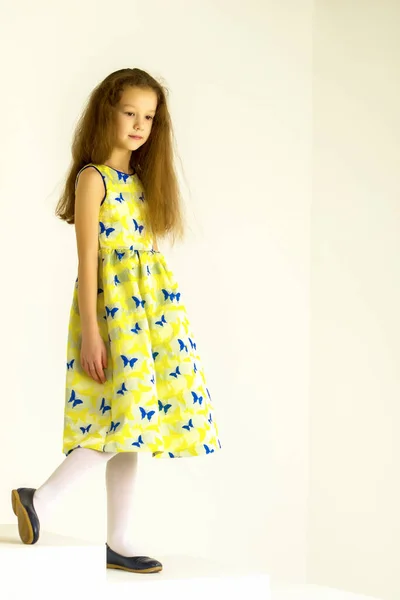 美しい女の子で黄色のドレスと靴立ち脚を置くオン — ストック写真