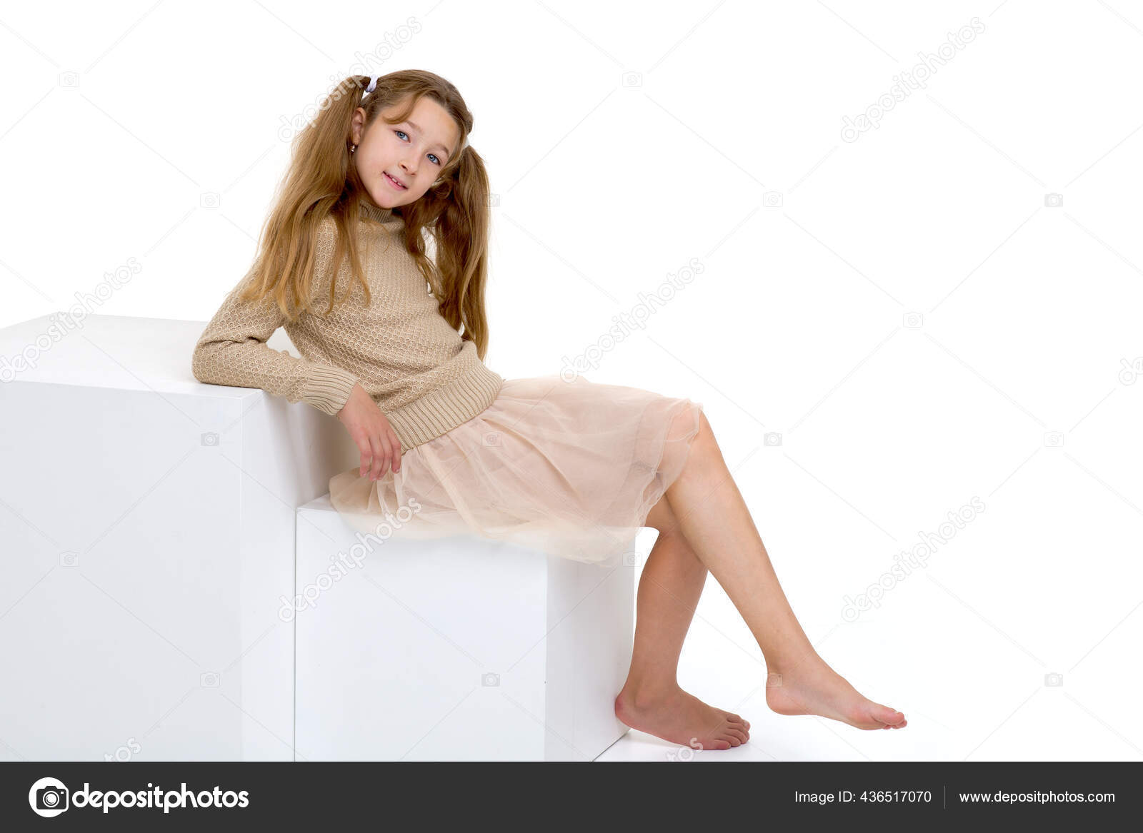 Beautiful girl sitting on a white cube — Stock Photo © lotosfoto1