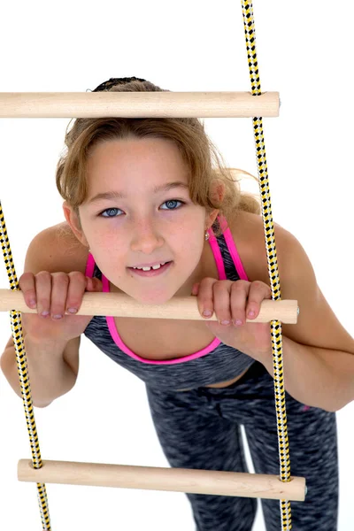 Menina realizando exercício de ginástica na escada de corda. — Fotografia de Stock