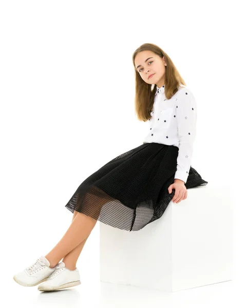 Adorável sorridente menina sentada no cubo branco e Gesturing — Fotografia de Stock