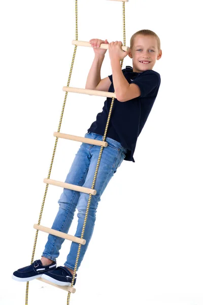 Tienerjongen klimt op touwladder — Stockfoto