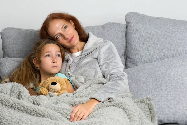 Máma sedí na gauči s dcerou — Stock fotografie