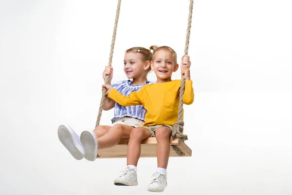 Gelukkige kinderen swingend op touw swing — Stockfoto