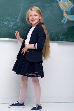 Güzel okul kızı tahtada duruyor.