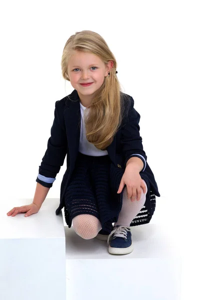 Dziewczyna w mundurze szkolnym siedzi na podłodze — Zdjęcie stockowe