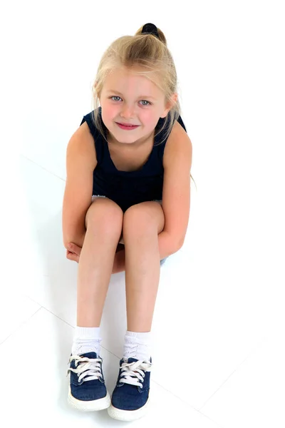 Bonito menina de seis anos sentada no chão — Fotografia de Stock