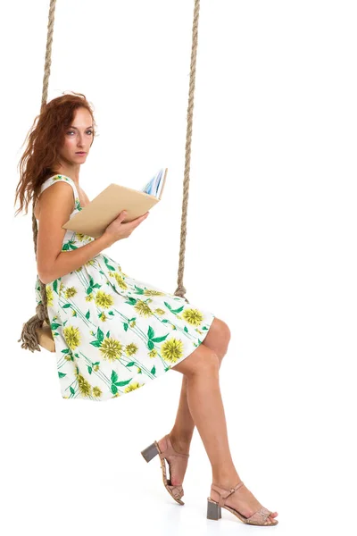 Mutlu genç kadın salıncakta kitap okuyor. — Stok fotoğraf