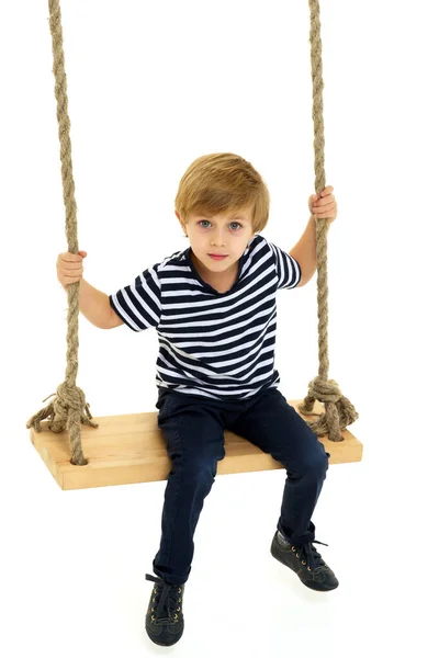 Cute boy sitting on rope swing — Stock Photo, Image